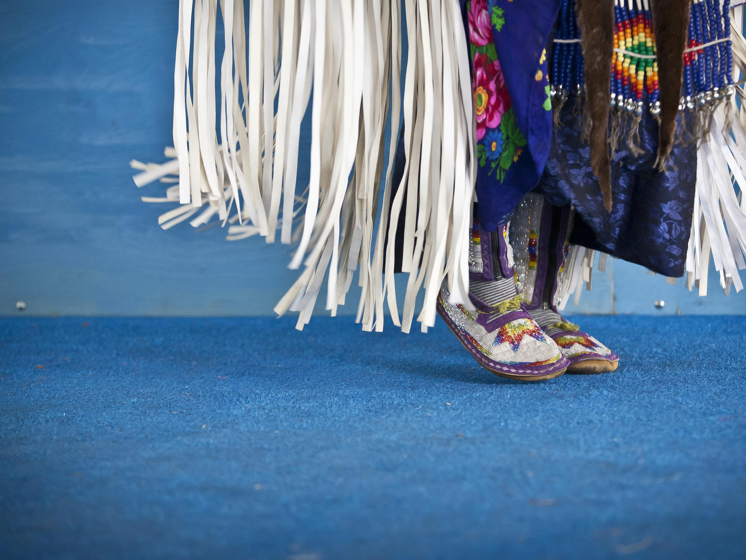 A close-up of a traditional dancer, regalia and mocassins