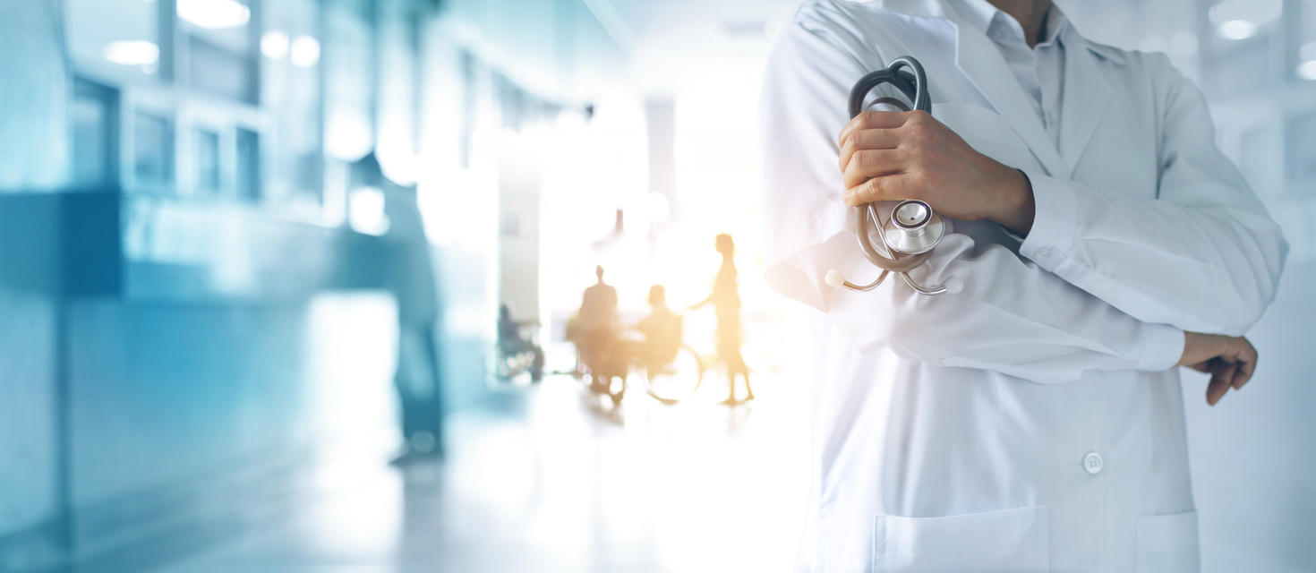 Docteur en médecine avec stéthoscope en main et les Patients viennent à l’arrière-plan de l’hôpital.