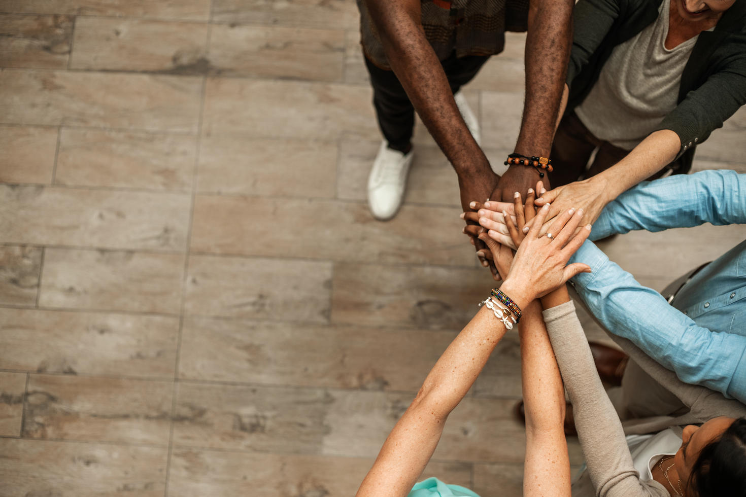 Groupe de personnes diverses en cercle se donnant la main en signe d'unité.