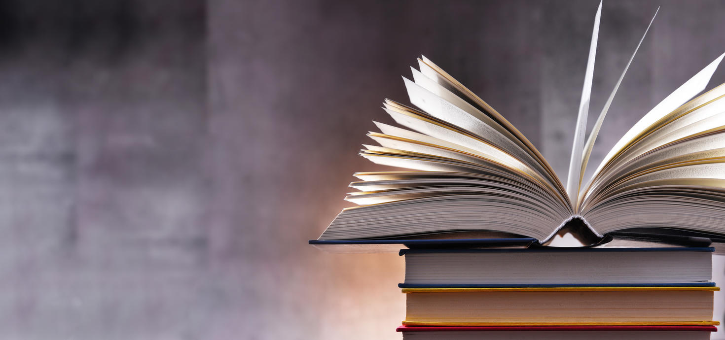 Livre ouvert posé sur une pile d'autres livres