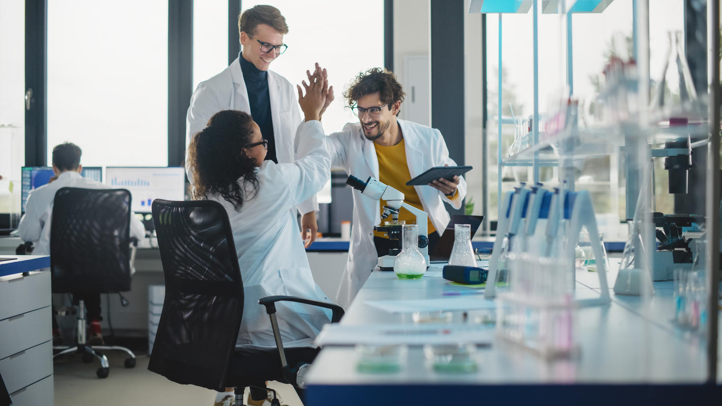 Deux scientifiques dans un laboratoire se tapent la main pour célébrer