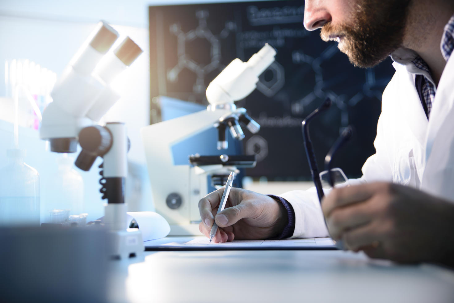 Un scientifique écrit sur un presse-papiers