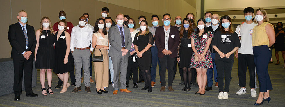 un grand groupe d'apprenants et de professeurs de médecine posent avec des masques faciaux.