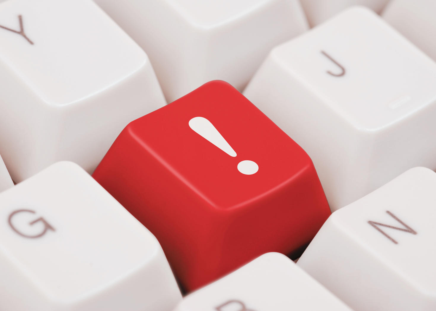 Gros plan d’une touche rouge de clavier avec un point d’exclamation blanc