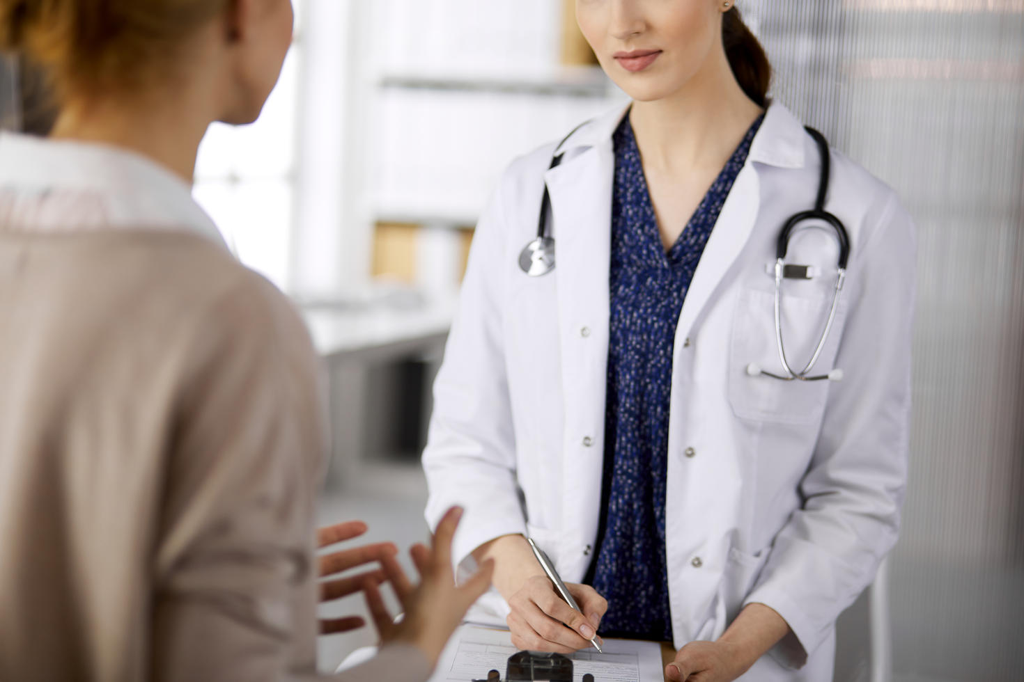 Médecin et patient discutant de l'examen de santé en cours, assis dans une clinique.