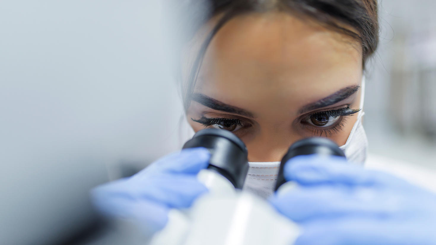 Étudiante diplômée regardant dans un microscope