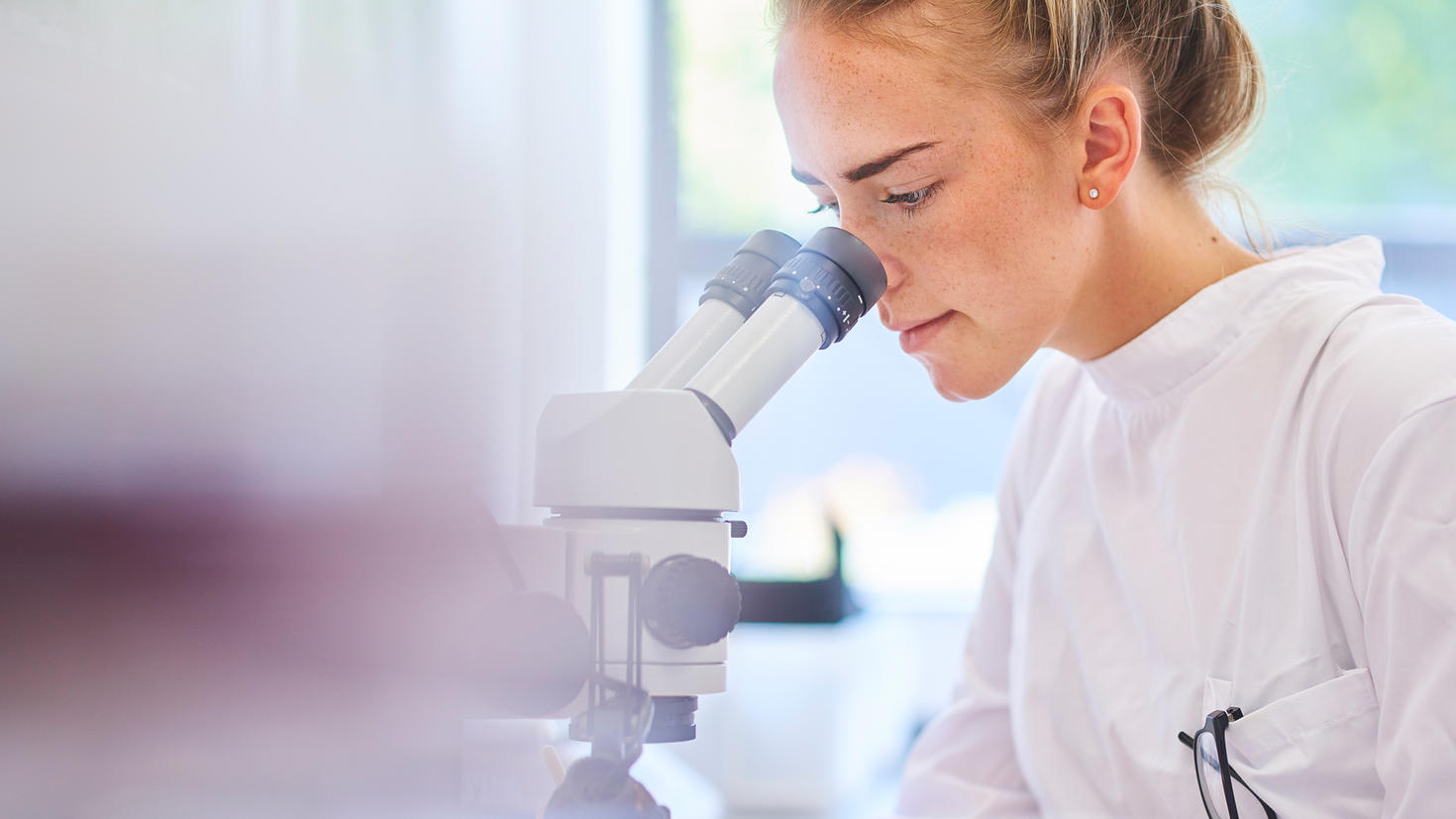 une étudiante utilisant un microscope dans un laboratoire