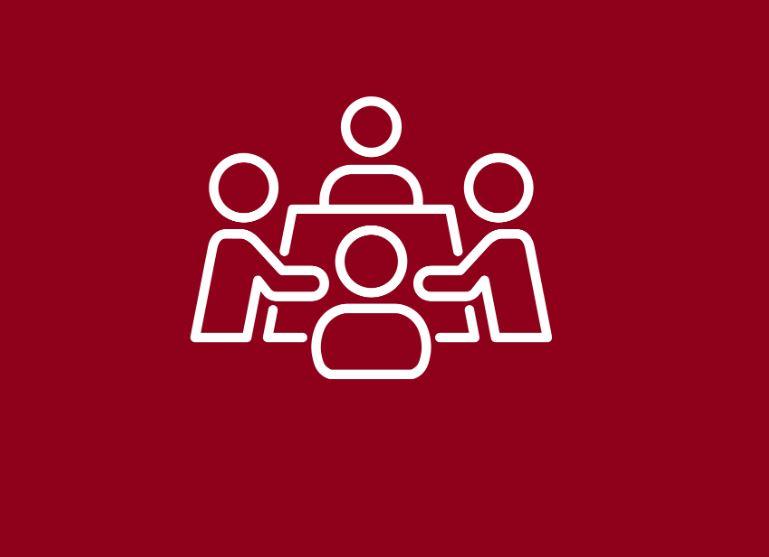 Vector icon of four people sitting along four edges of a table