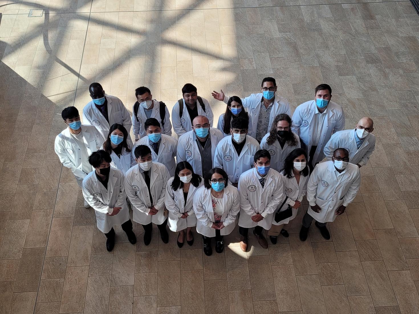 Groupe de personnes debout en blouse de laboratoire