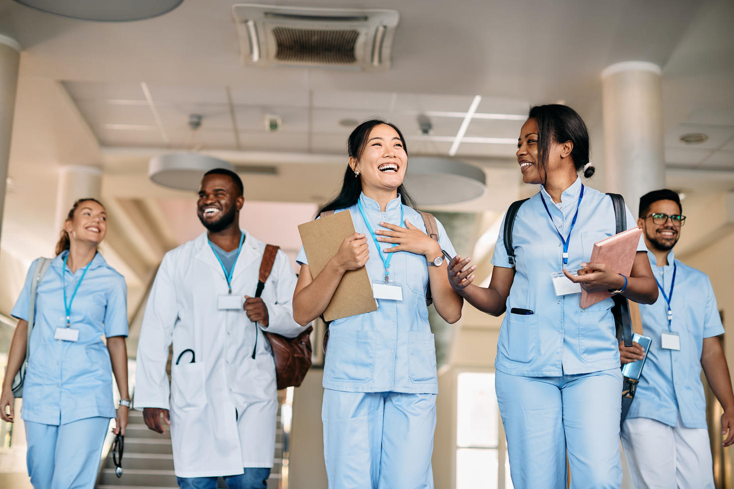 Joyeux groupe multiethnique d'étudiants en médecine s'amusant tout en discutant dans un couloir