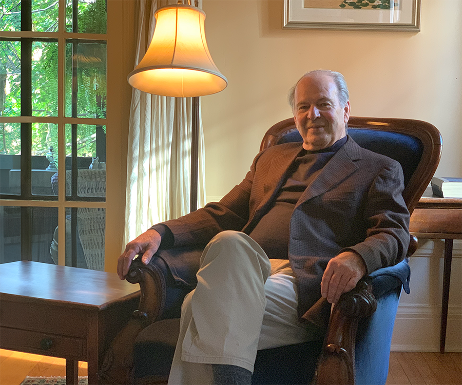 Le Dr. Pierre Morisset est assis dans un fauteuil chez lui.