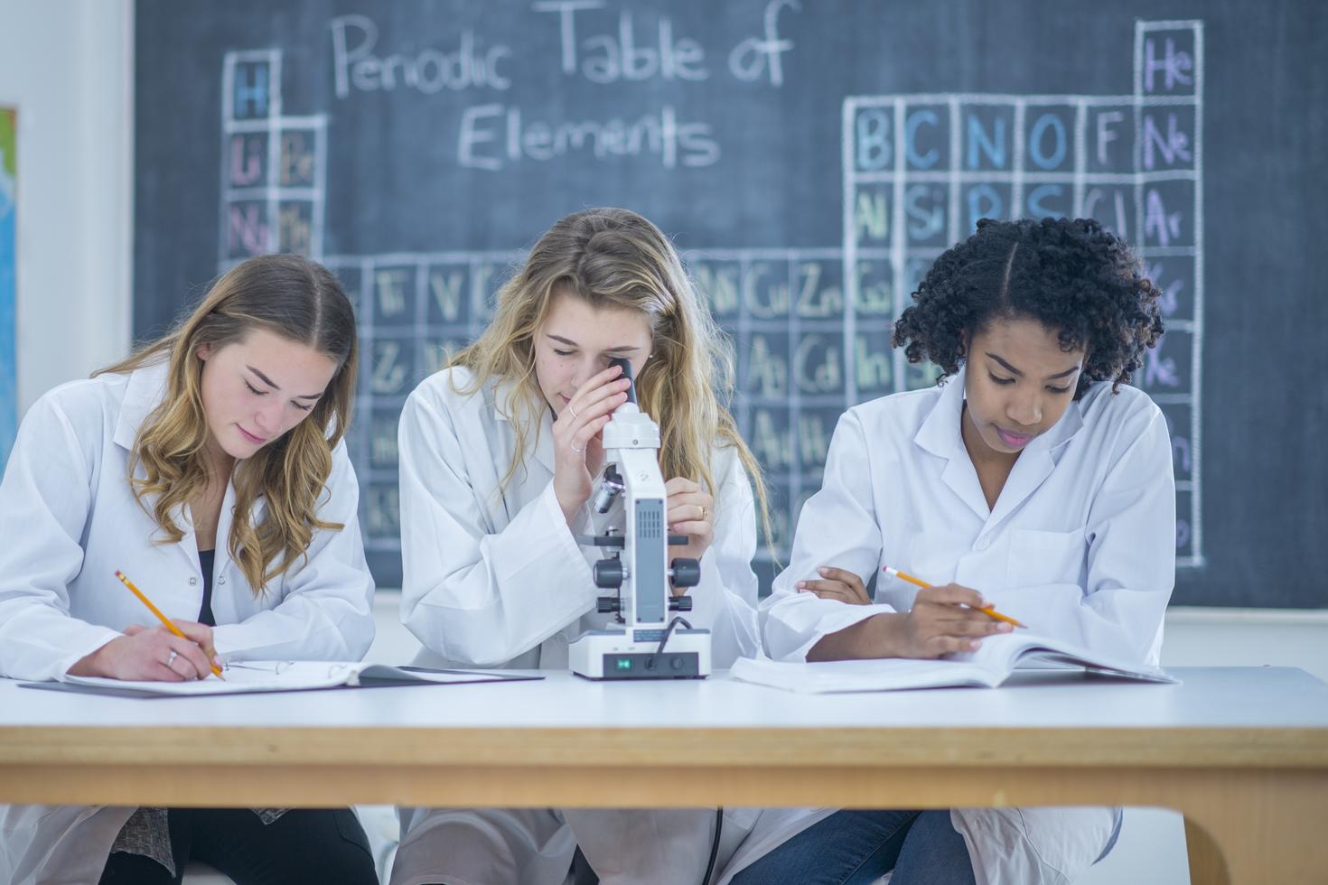Un groupe d'étudiantes se trouvent à l'intérieur d'un laboratoire de sciences.