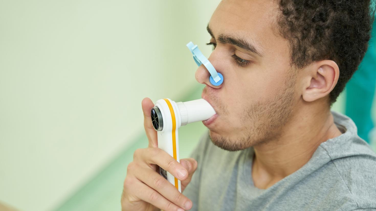 Patient vérifiant sa fonction pulmonaire à l'aide d'un spiromètre