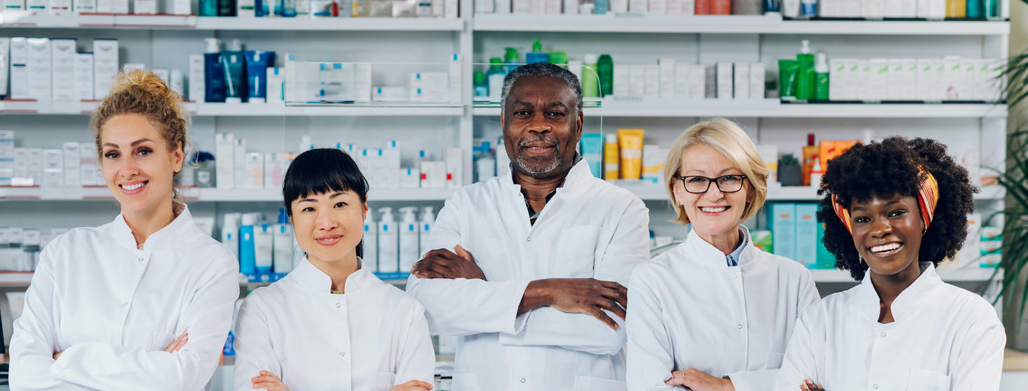 Professionals are standing in the pharmacy with their arms crossed