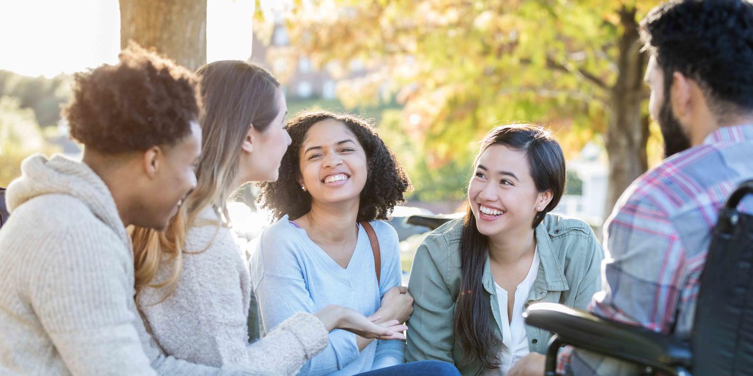 Groupe d’amis d’université parlant en cercle à l’extérieur