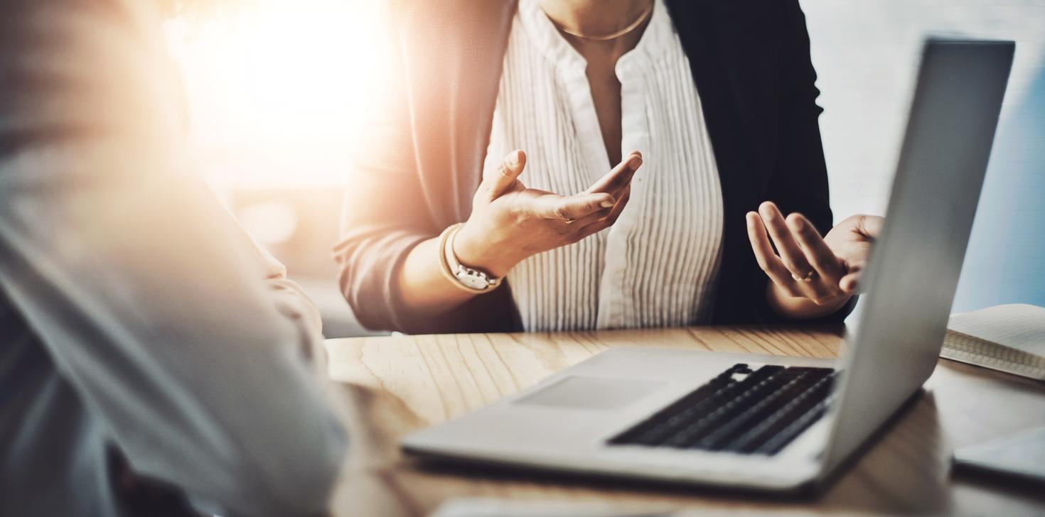 Réunion, mains et ordinateur portable dans un bureau pour planification, discussion et stratégie autour d'une table