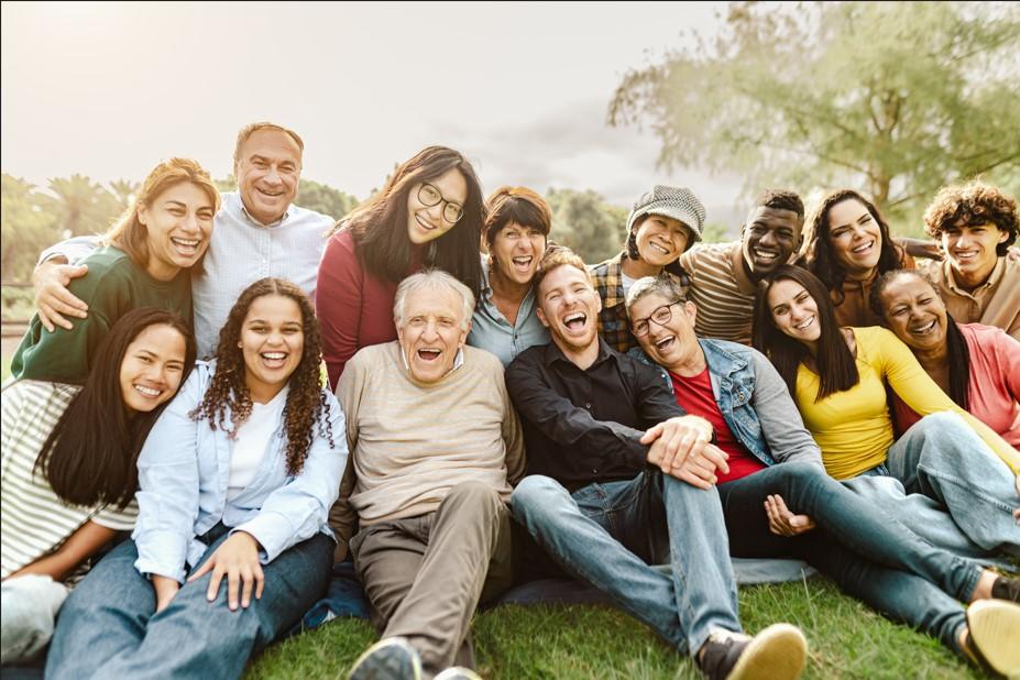 groupe multigénérationnel heureux assis dans un parc, souriant