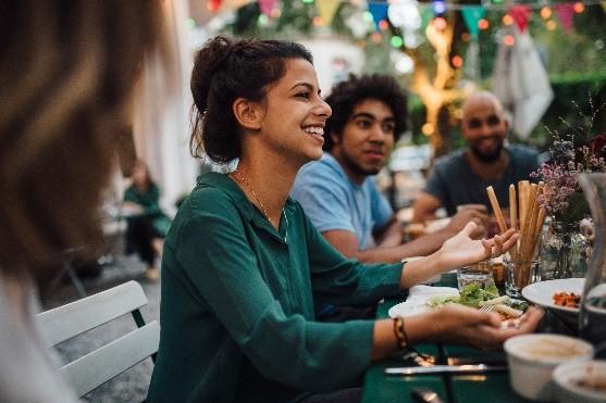 Des clients heureux dînent ensemble sur la terrasse d'un restaurant
