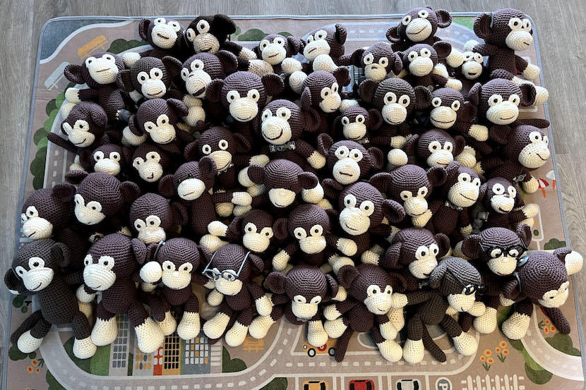 Un grand nombre de singes au crochet assis sur un tapis.