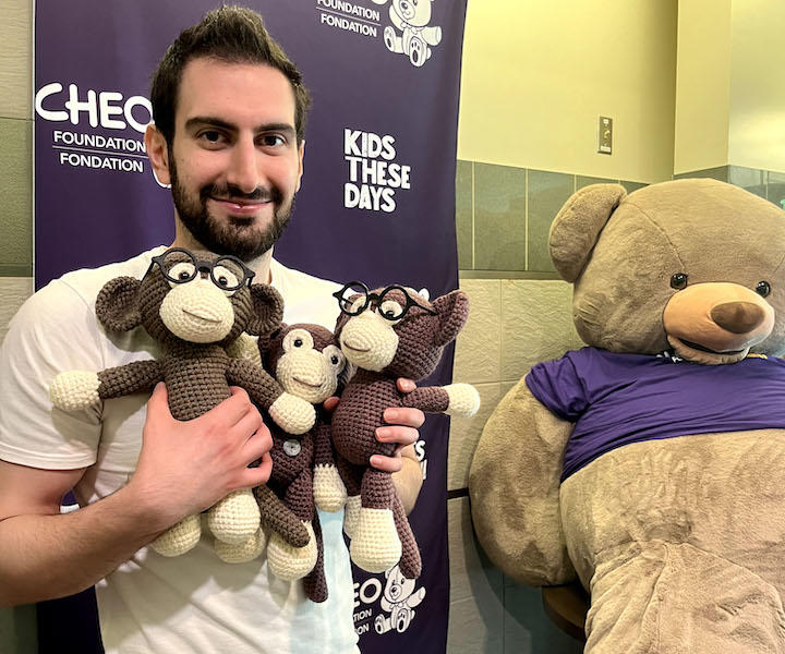 Un étudiant en médecine tenant trois singes au crochet.