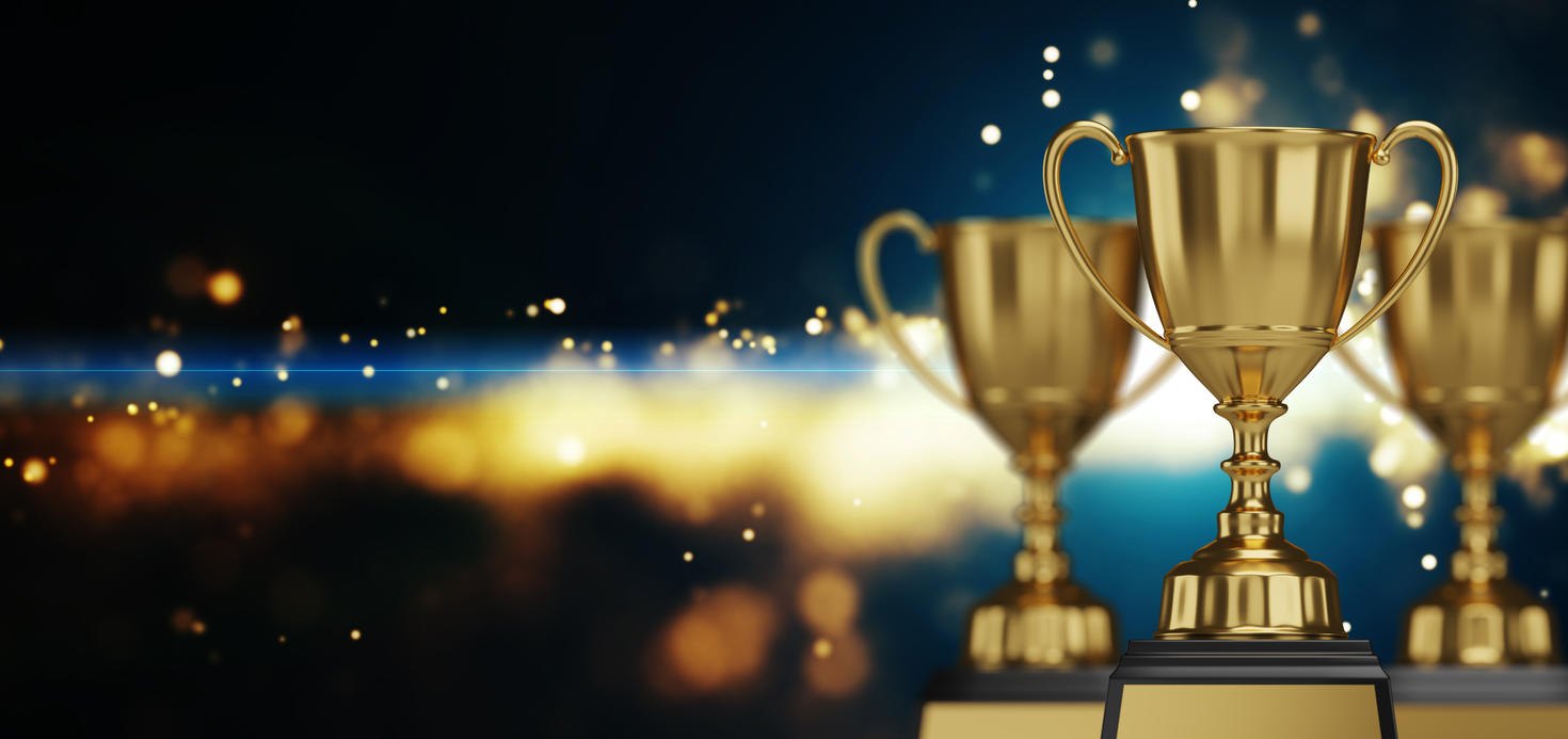 Gros plan d’un trophée doré avec des confettis tombants. Espace libre pour le texte.