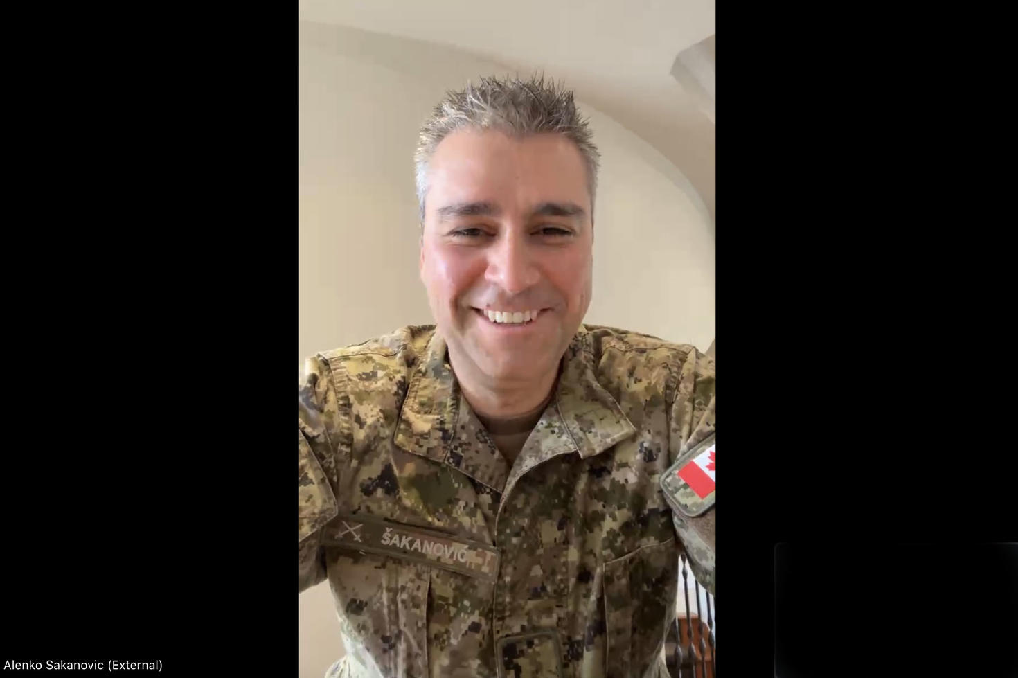 Une personne en uniforme militaire sourit pour une photo.