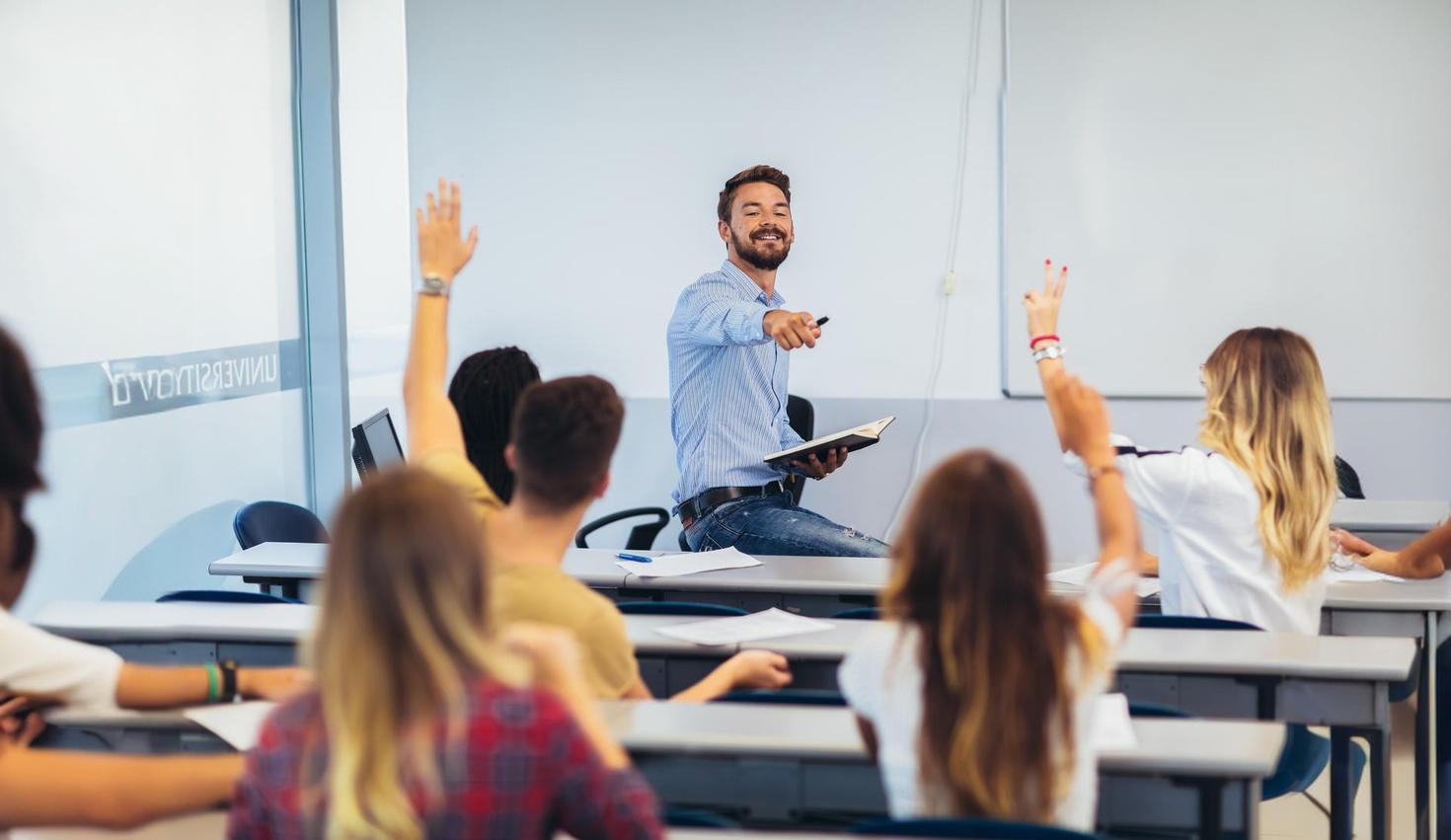 Des lycéens lèvent la main en classe