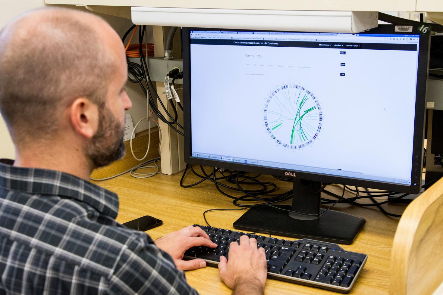 Génotypage et séquençage de l'ADN. Un bioinformaticien analyse des données d'intégration de l'ADN du virus du papillome humain (VPH) au Laboratoire de recherche en génomique du cancer, qui fait partie de la Division de l'épidémiologie et de la génétique du cancer (DCEG) de l'Institut national du cancer. La bio-informatique a pour objectif principal de stocker, d'analyser, d'intégrer et de visualiser de grandes quantités de données biologiques et d'informations connexes, ainsi que d'en faciliter l'accès.  Tr