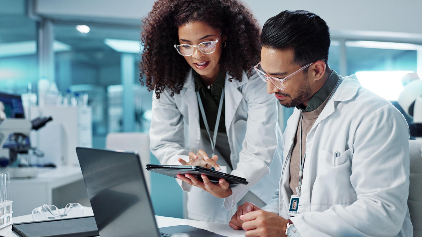 deux chercheurs regardant une tablette dans un laboratoire moderne