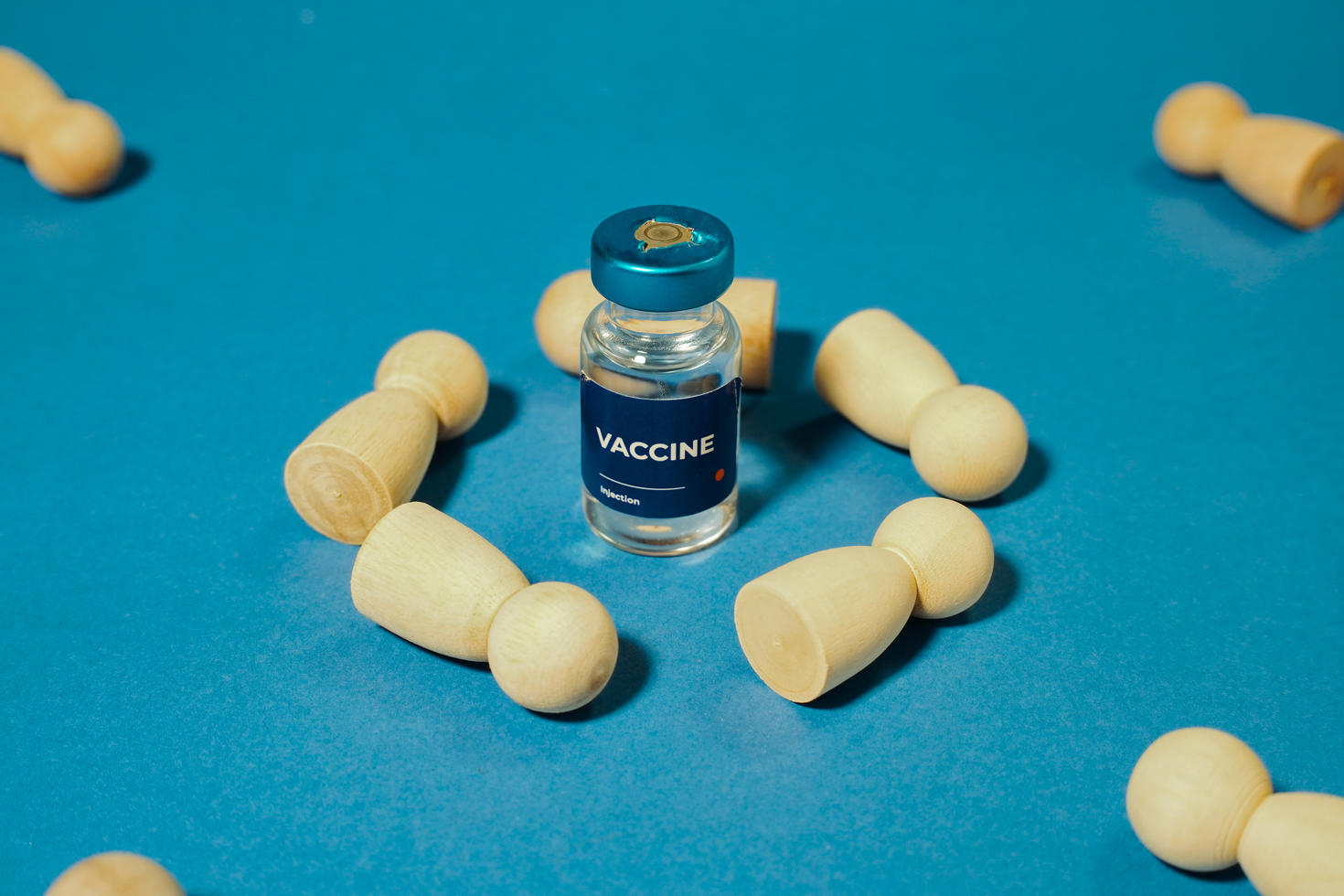 Divers comprimés et capsules disposés autour d’un flacon de médicament sur un fond bleu.