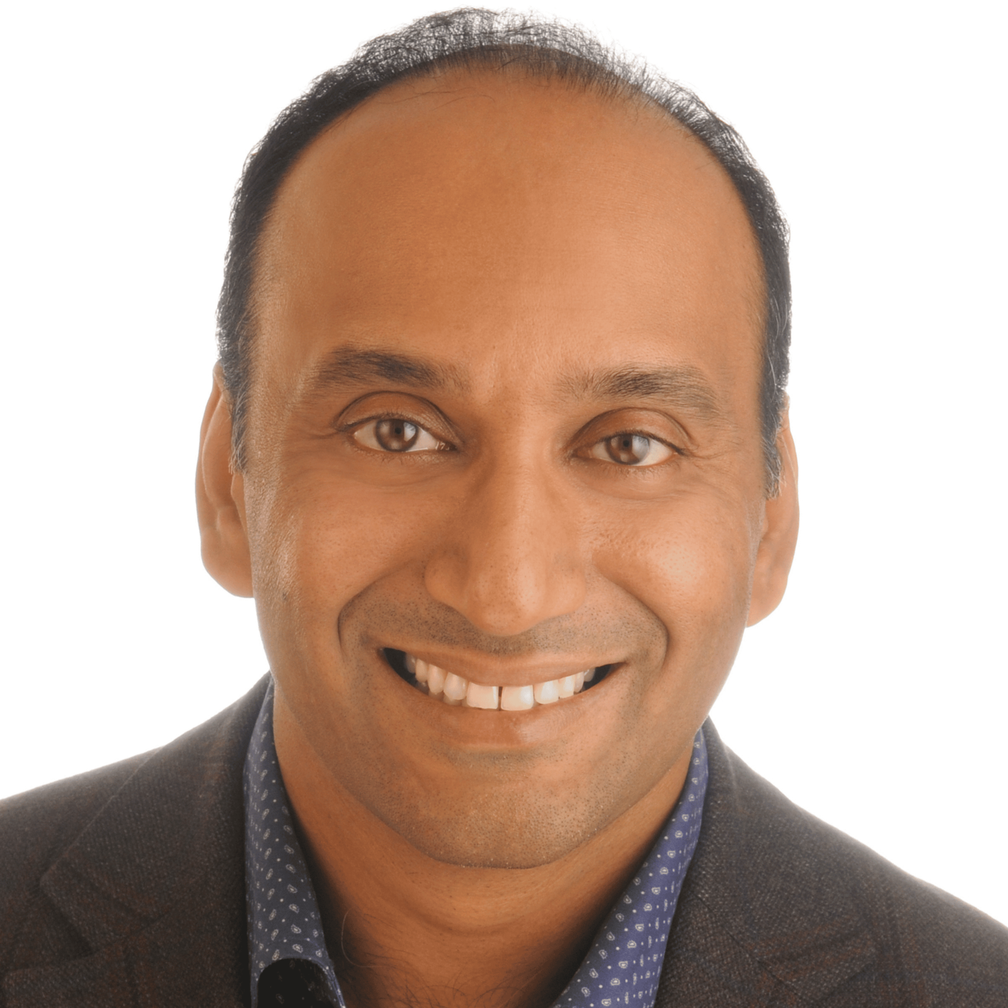 Le Dr Arun Radhakrishnan sourit et porte un complet gris anthracite foncé ainsi qu’une chemise habillée à motif vichy bleu, sur un arrière-plan blanc.