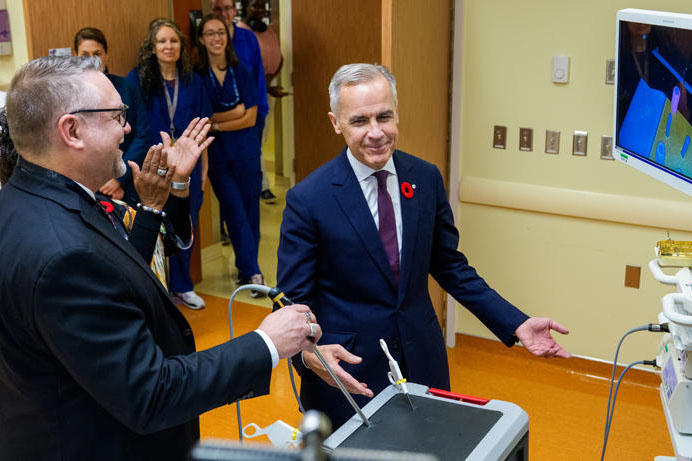 Le premier ministre du Canada, Mark Carney, sourit tout en essayant un équipement au Centre de compétences et de simulation de l’Université d’Ottawa.