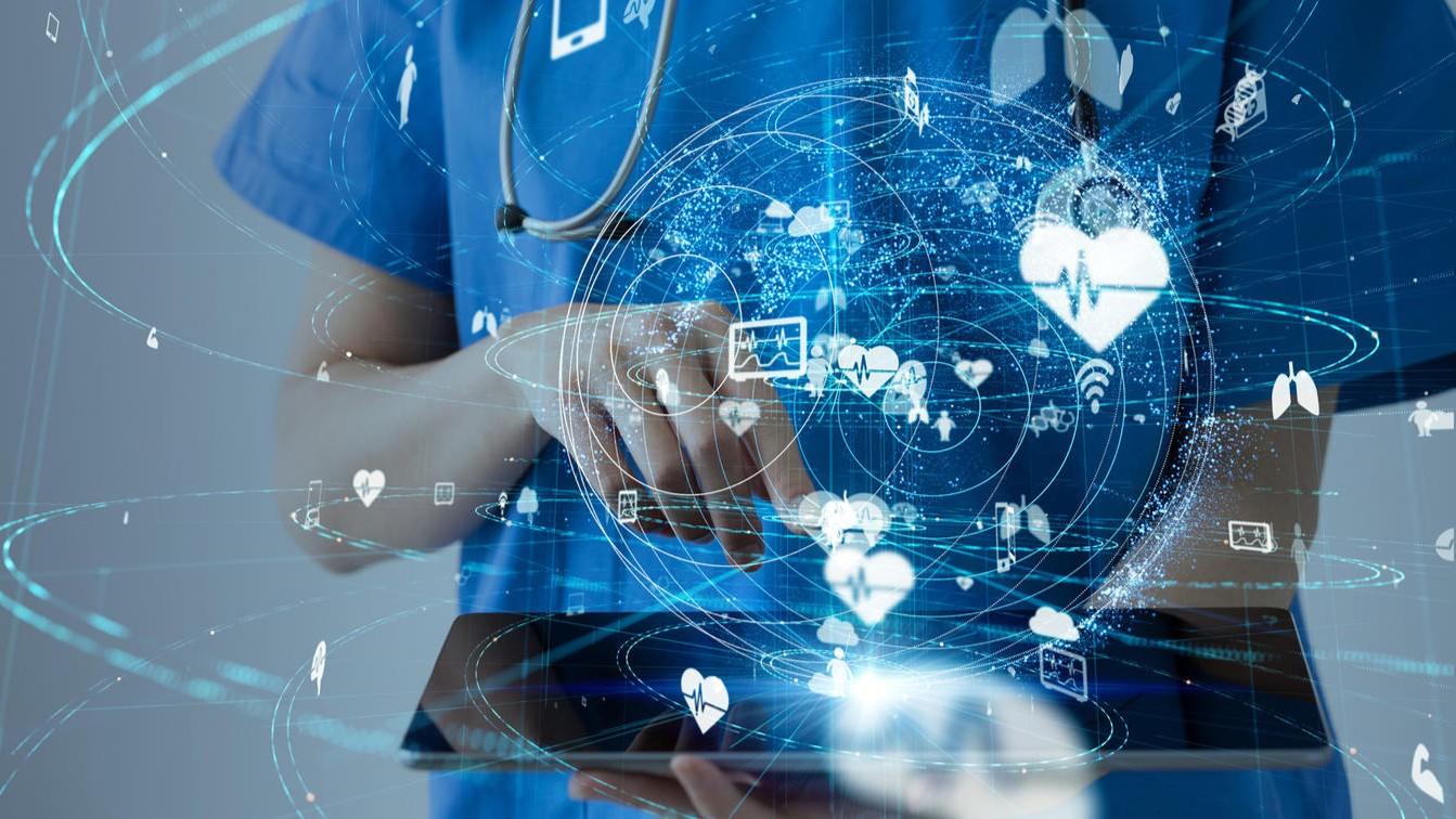 Un professionnel de santé vêtu d'une blouse bleue utilise une tablette au milieu d'icônes médicales lumineuses