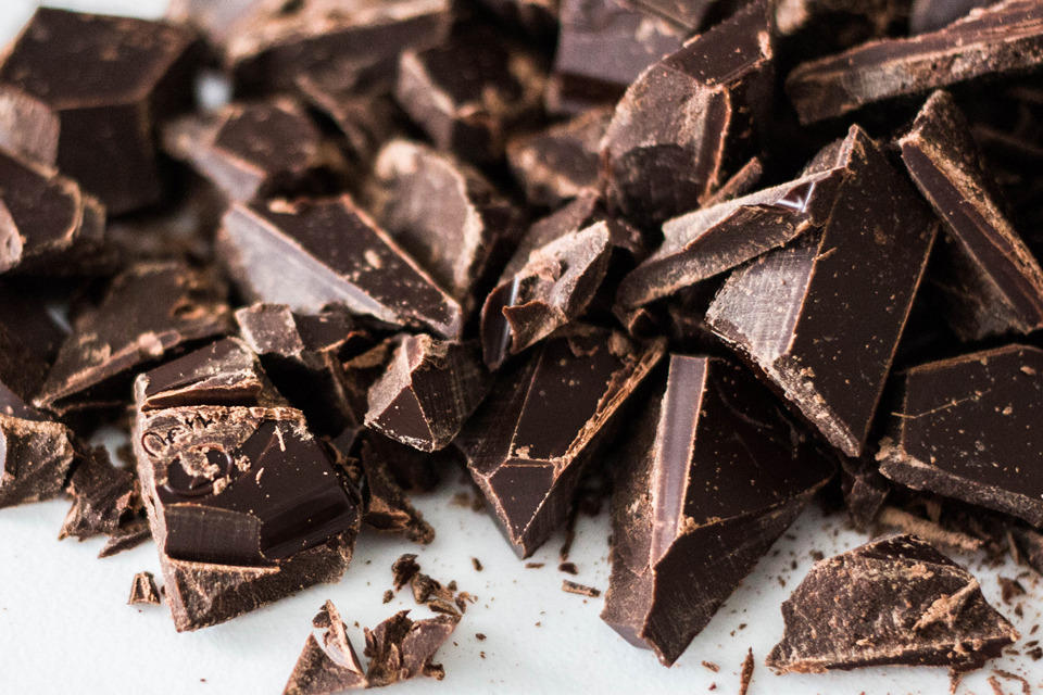 Une montagne de carrés de chocolat sur une surface.