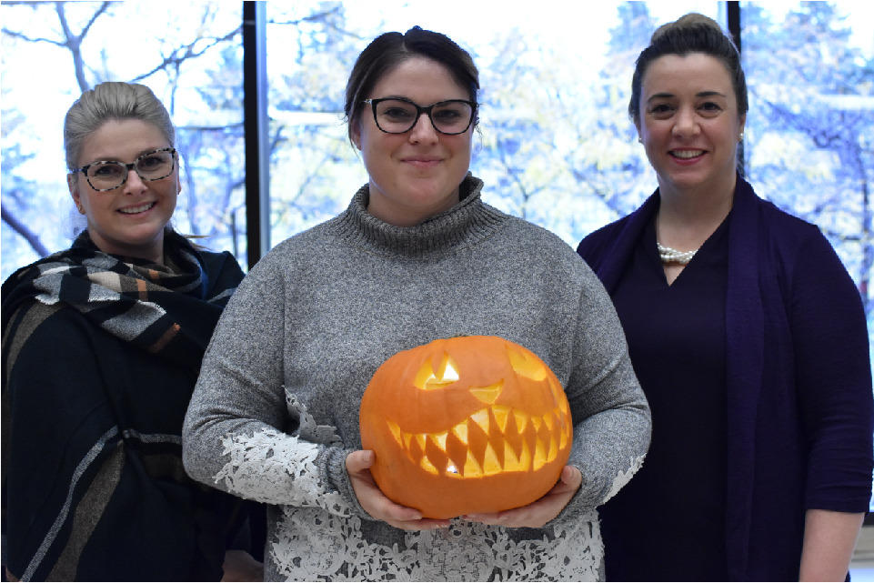 Josée Lortie et Michelle Émard se tiennent aux côtés de Jenn Therrien, qui tient une citrouille souriante.
