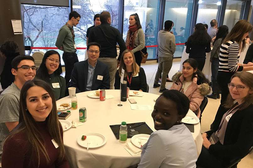 Une photo d'étudiants et de professeurs assis à une table.