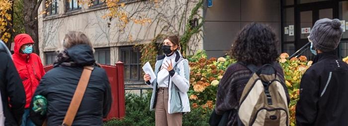 Jeune étudiante parlant a un groupe de visiteurs dehors sur le campus de l'Université d'Ottawa