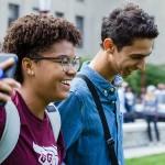 Deux étudiants marchant côte à côte et qui sourient