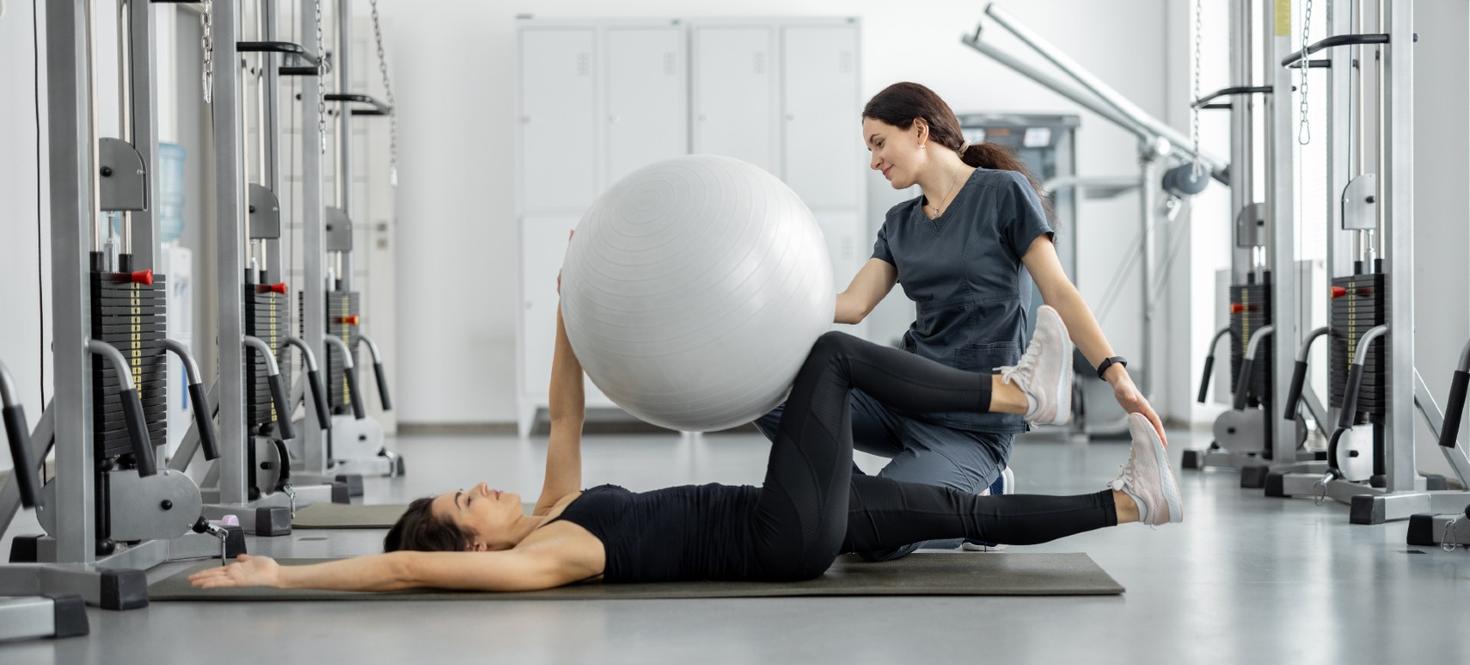 Femme travaillant avec une autre femme en utilisant un ballon d'exercice
