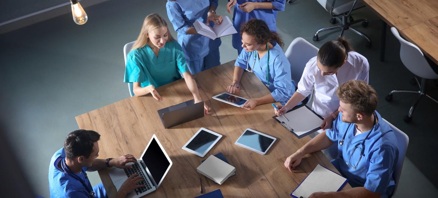 Un groupe d'étudiants en soins infirmiers diplômés travaillant ensemble à une table.