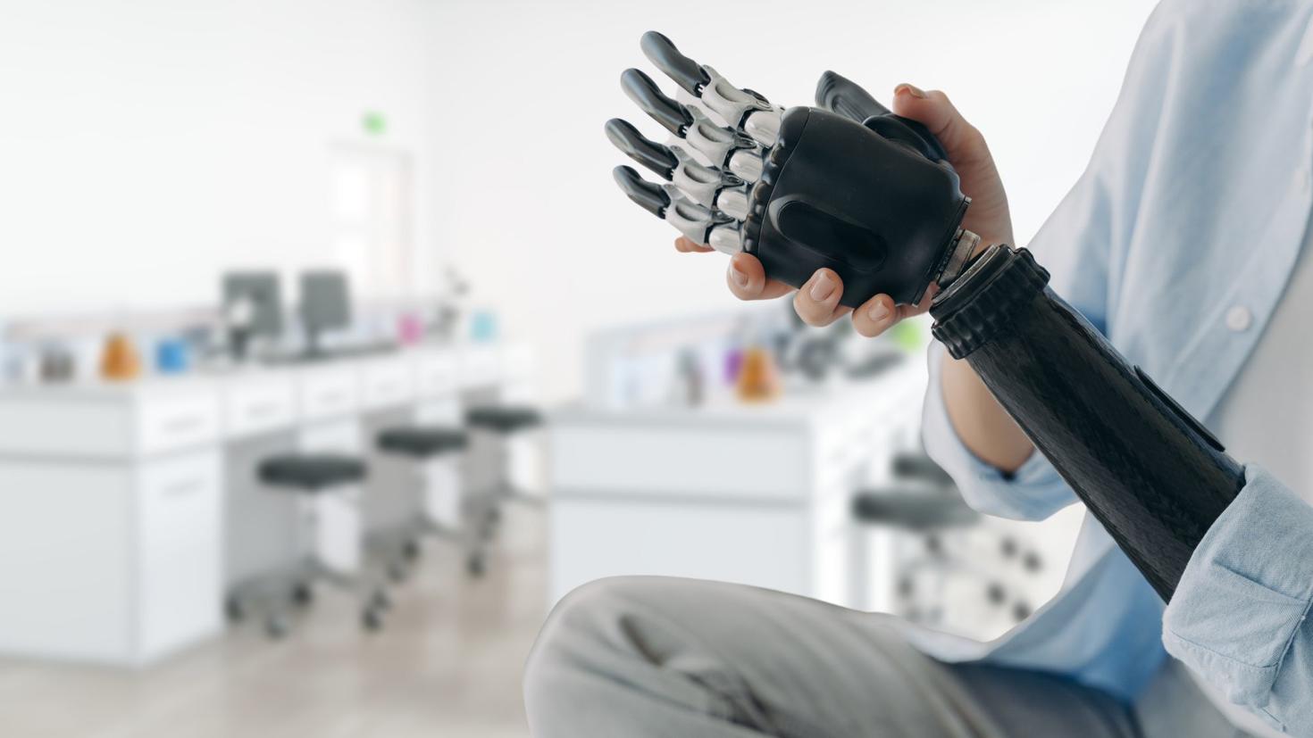 Personne dans un laboratoire portant une prothèse de bras