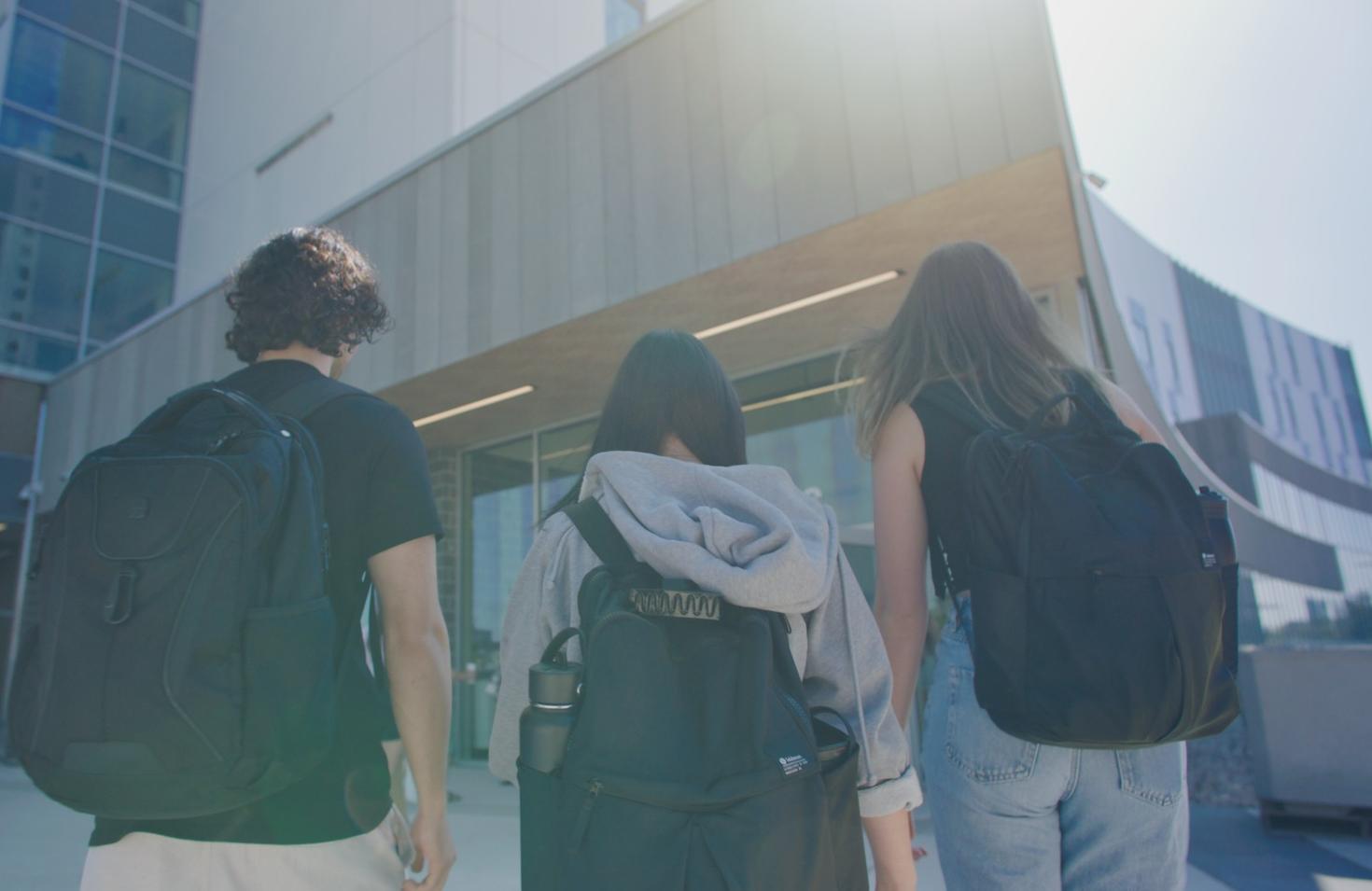 three students walking into a building together