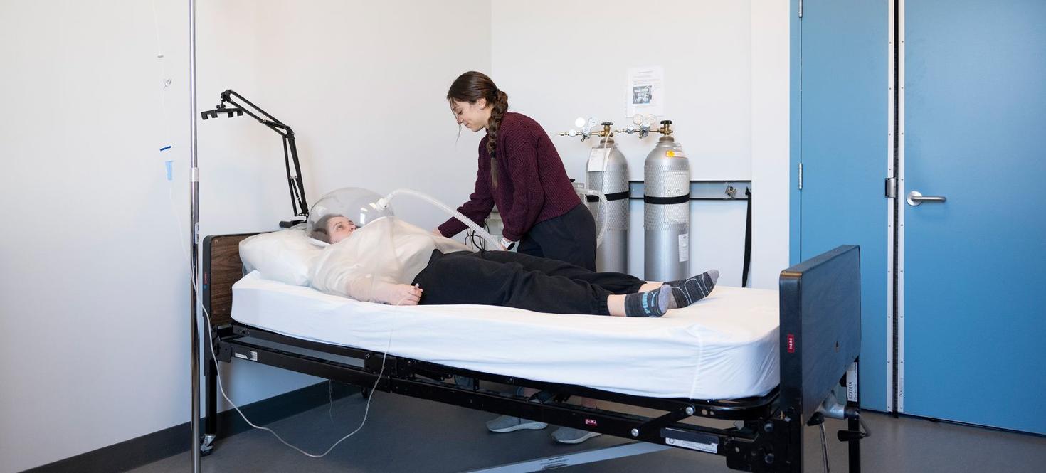 femme dans un lit avec un appareil respiratoire spécial dans le cadre d'une étude de recherche