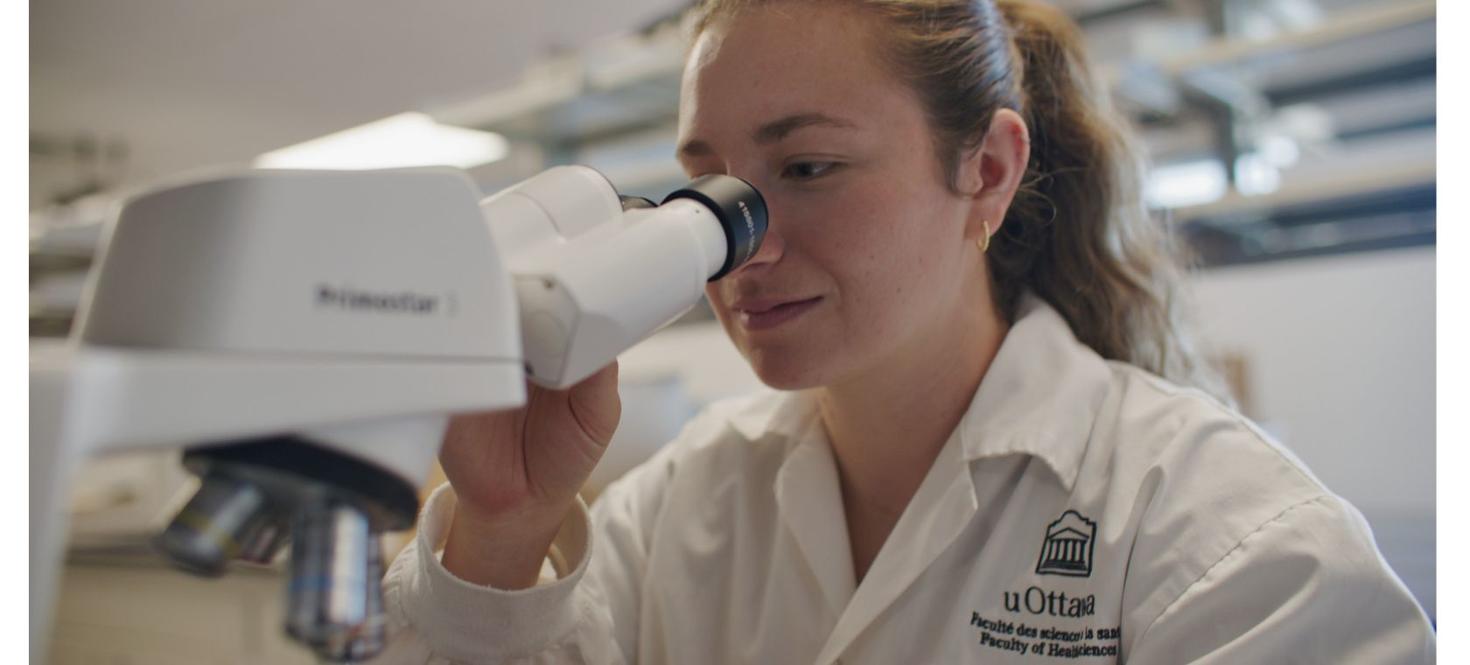 Étudiante regardant à travers le microscope