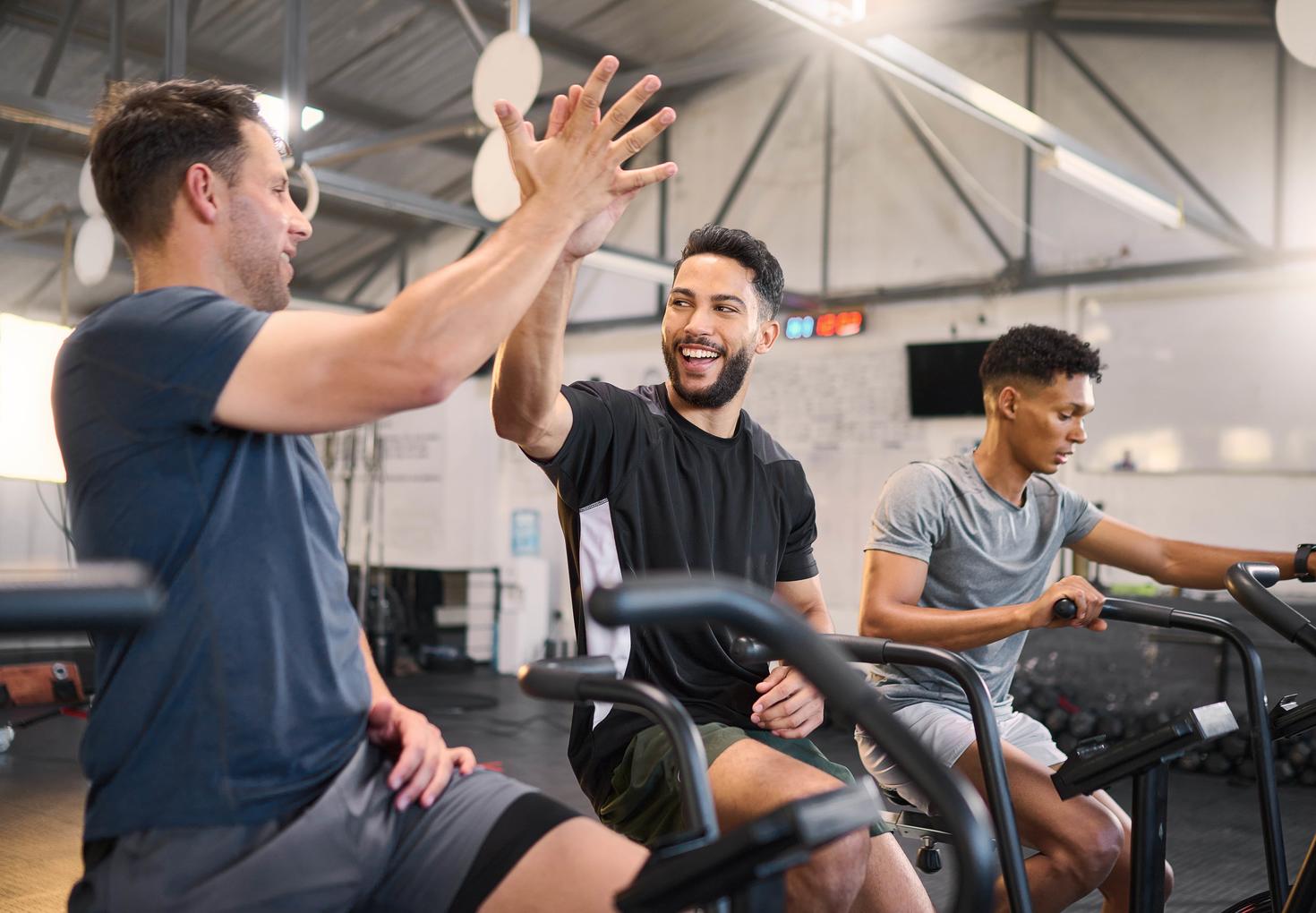 Trois étudiants utilisent des machines cardio pour faire de l'exercice dans le gymnase.