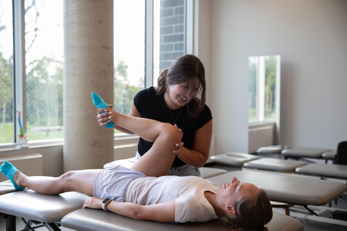 Deux étudiants en physiothérapie pratiquant des techniques l'un sur l'autre dans un laboratoire.