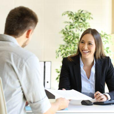 Homme et femme en réunion, femme en costume d'affaires souriante