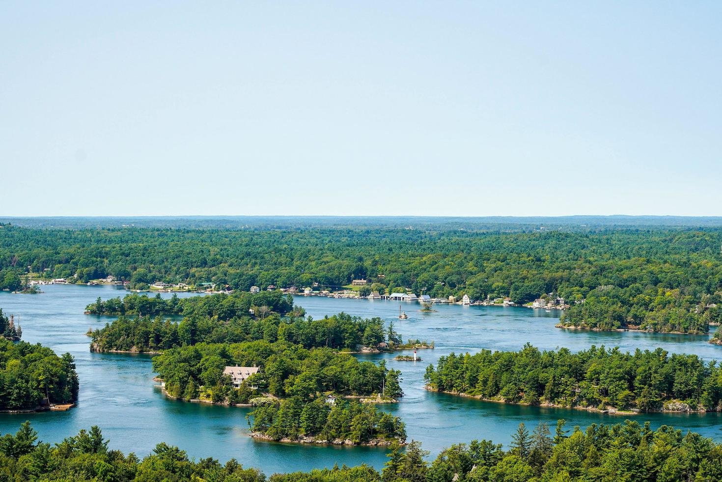 Une vue aérienne d'un paysage fluvial pittoresque avec des îles verdoyantes sous un ciel clair.