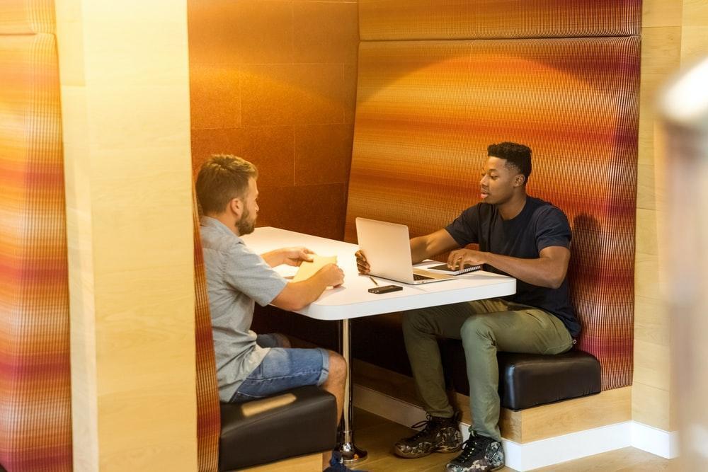 Deux étudiants assis en face l'un de l'autre à une table