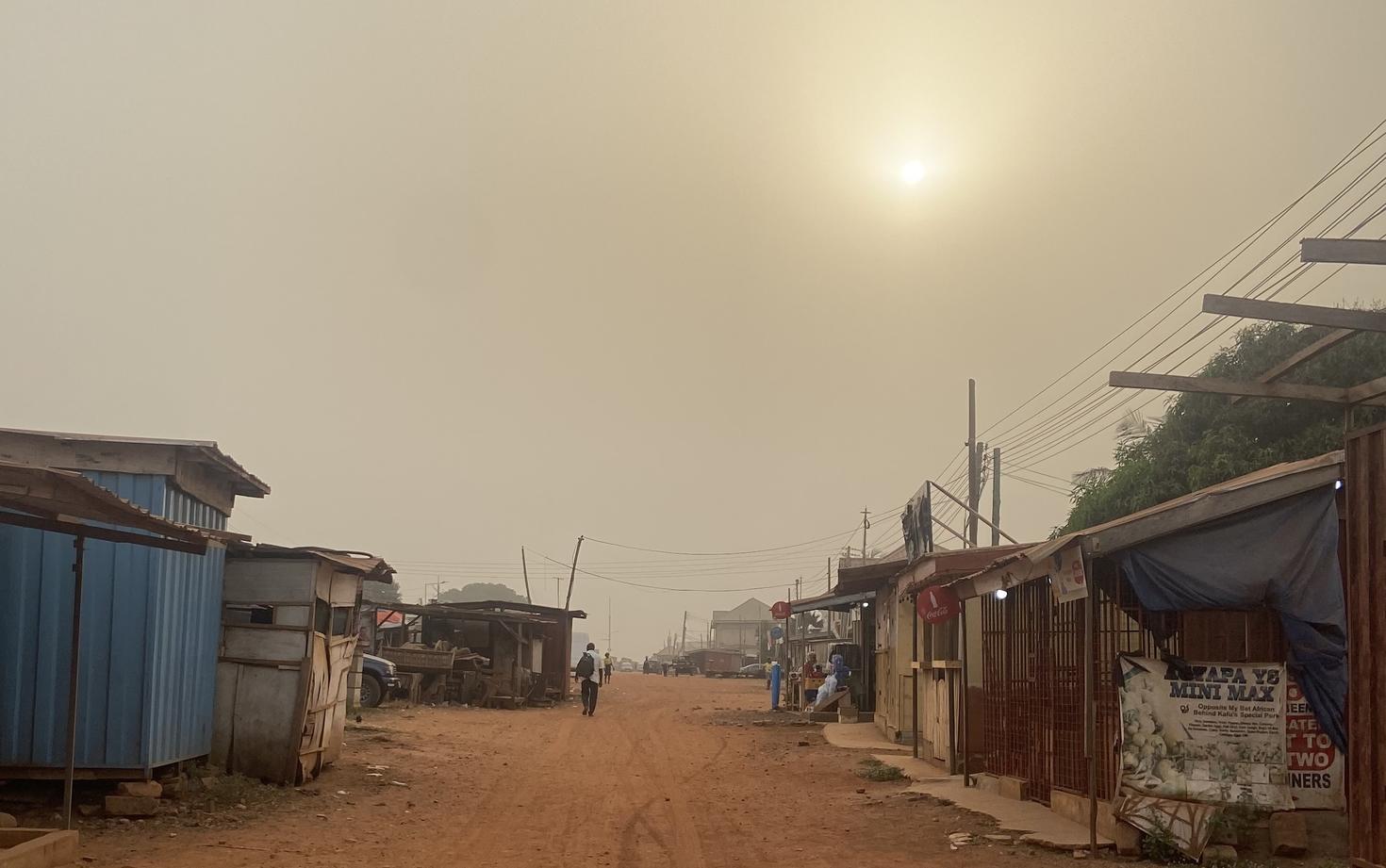 Quartier au Ghana avec de nombreuses petites maisons autour et du sable partout sur le sol